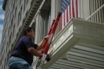 Person climbing ladder near American flag.
