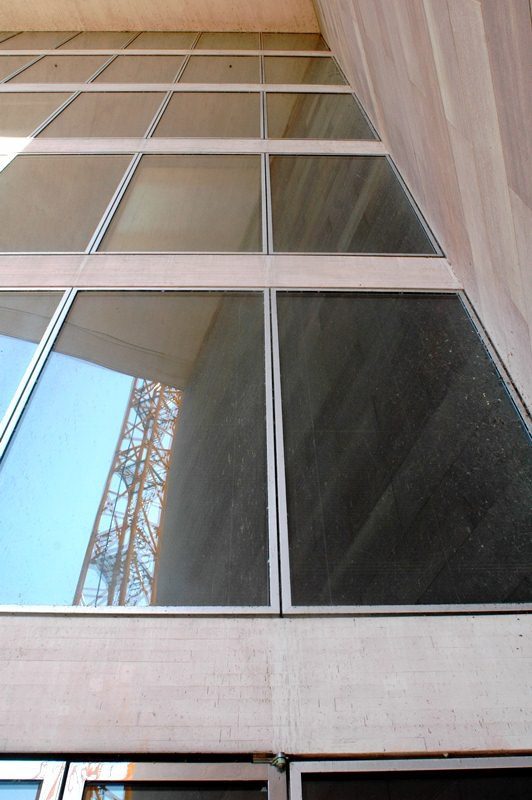 Glass building facade with sky reflection.