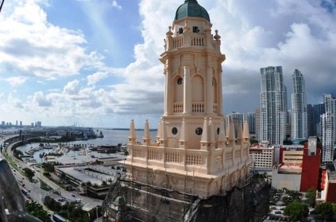 Historic tower with city skyline in background.